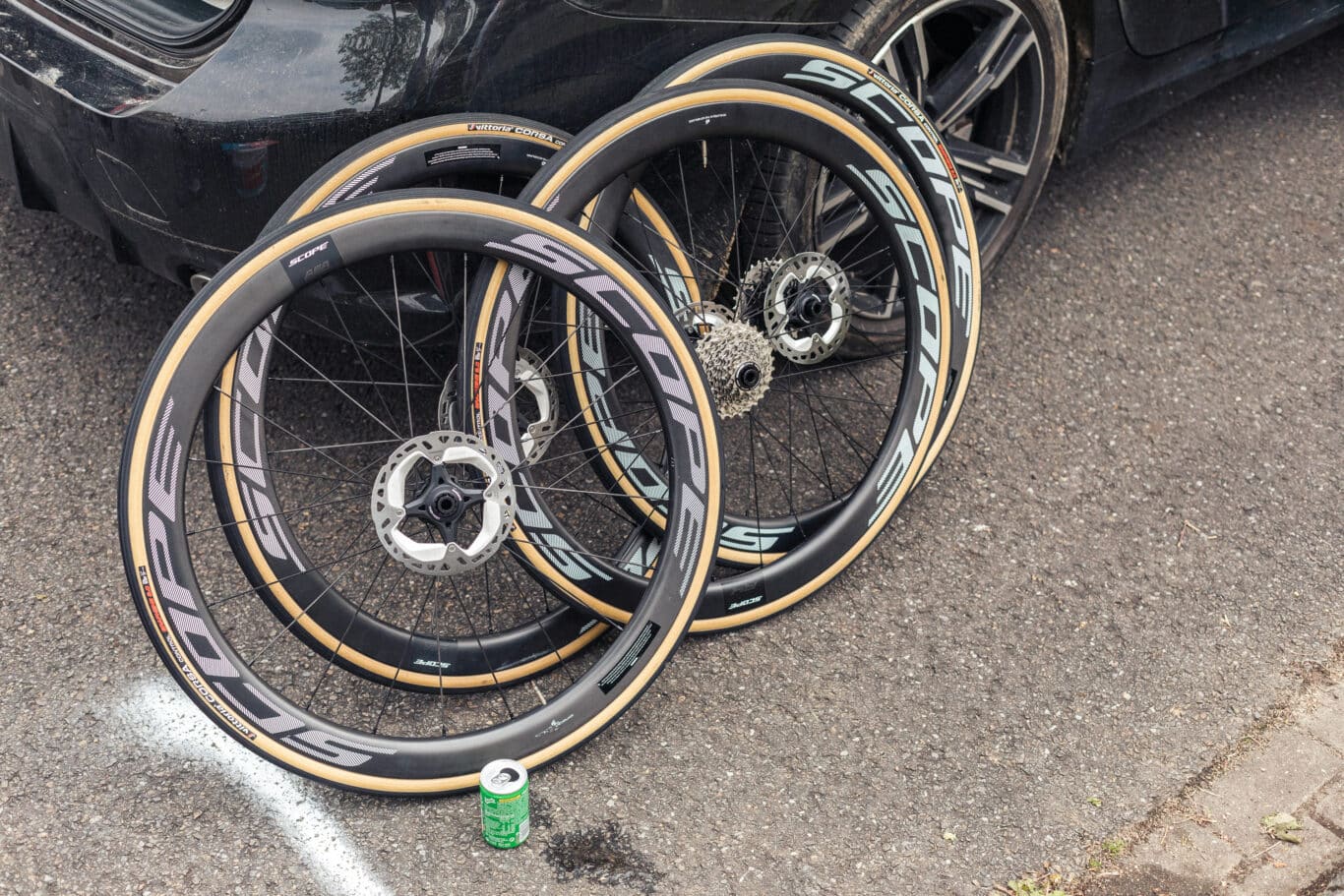A bunch of Scope wheels standing against a black car